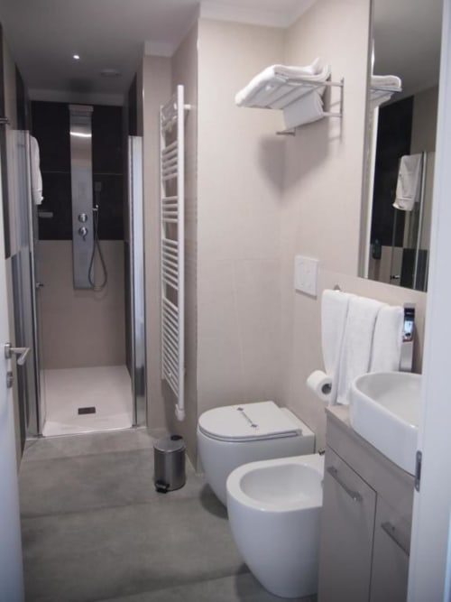 Bagno moderno nella Suite Superior di Hotel Vienna con sanitari bianchi, doccia walk-in, scaldasalviette e pavimento in marmo