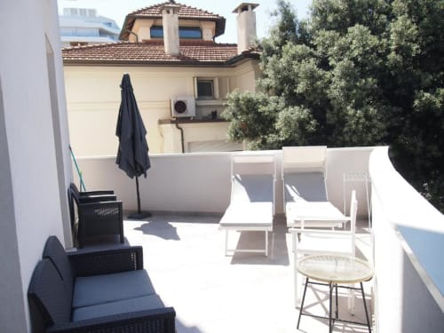 Terrazza della Suite Superiore all'Hotel Vienna di Pesaro con sedute lounge, ombrellone e vista sulla città con edifici storici