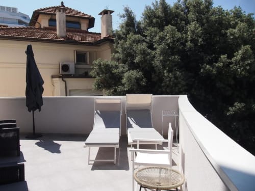 Terrazza della Suite Superiore presso l'Hotel Vienna Pesaro con lettini, ombrellone e vista sulla città
