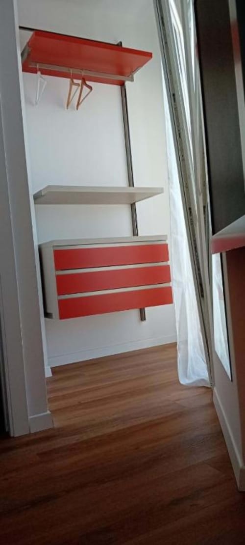 Moderna ripostiglio con scaffalature rosse e bianche all'Hotel Vienna di Pesaro