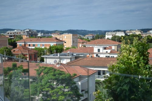 Vista aerea dell'Hotel Vienna a Pesaro, Italia con tetti in laterizio, edifici residenziali e lussureggiante vegetazione verde