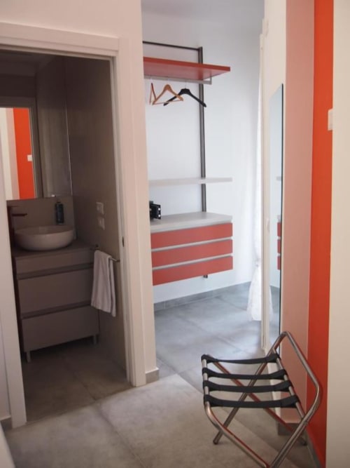 Camera singola Hotel Vienna Pesaro con armadio rosso e bianco, bagno e arredamenti moderni