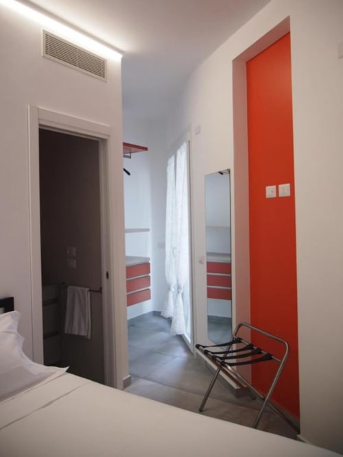 Corridoio moderno dell'Hotel Vienna Pesaro con parete rossa accent, porta scura e specchio