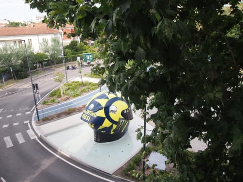 Scultura di casco da moto giallo e blu navy su strada a Pesaro, Italia vicino all'Hotel Vienna