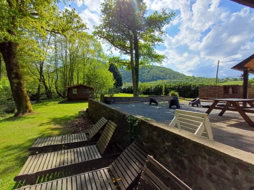 Espace détente extérieur du Gîte des Mousquetaires avec jardin, arbres et vue sur la vallée à Lanne en Barétous