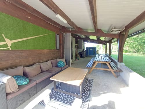 Patio couvert avec coin détente au Gîte des Mousquetaires, maison d'hôtes des Pyrénées avec poutres en bois rustique