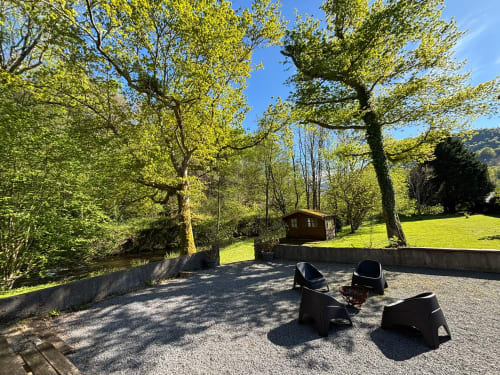 Espace de détente extérieur du gîte des mousquetaires à Lanne en Barétous, entouré de verdure luxuriante et de prairies