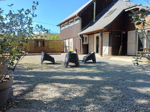 Cour du gîte des mousquetaires avec chaises noires et clôture en bois à Lanne-en-Bâretous