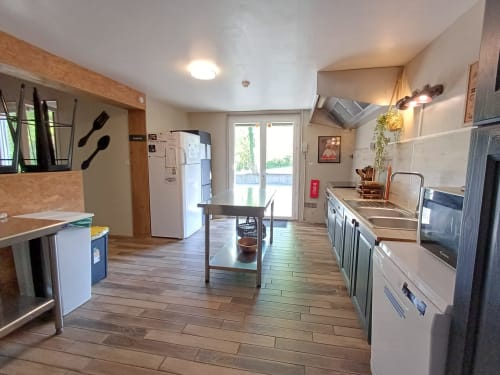 Modern kitchen in Le gite des mousquetaires BnB, Lanne en Baretous, with wooden floors and stainless steel appliances