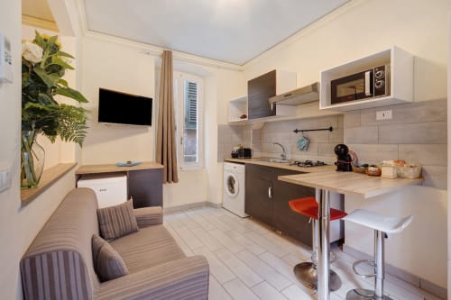 Modern studio kitchen and living area at Casa Scola Loano BnB in Loano, Italy with kitchenette and sofa