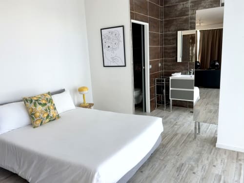 Suite moderne de l'hôtel La Girafe avec lit, vue sur le jardin, salle de bain attenante et mobilier contemporain