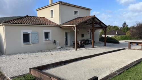 Gîte la Villa des Falaises du Lot : façade, patio, pergola en bois et terrain de pétanque à Tour de Faure