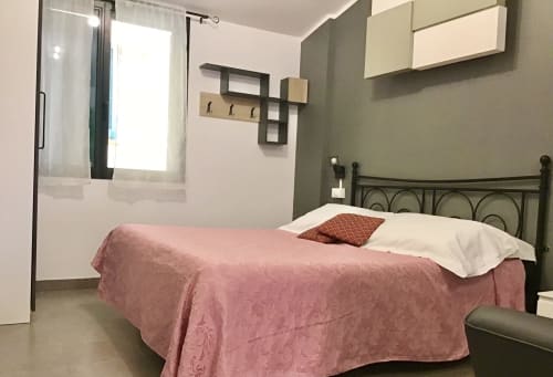 Camera moderna di Casa Scola Loano B&B con biancheria rosa, letto in metallo e bagno privato a Loano