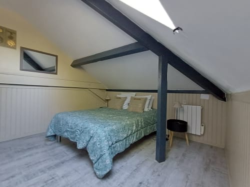 Attic bedroom at Le gite des mousquetaires with exposed beams, queen bed, and sloped ceilings in Lanne en Baretous