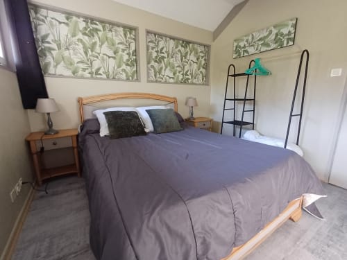 Cozy bedroom at Le gite des mousquetaires in Lanne en Baretous with queen bed, botanical art, and wooden furnishings