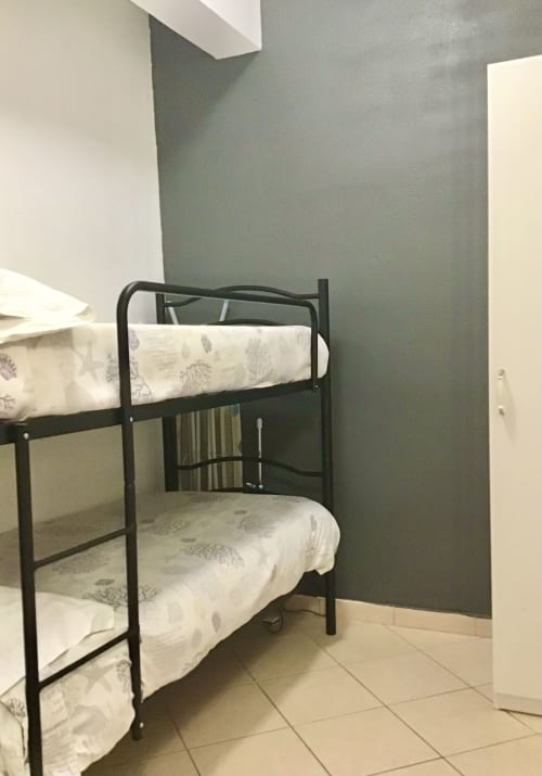 Bunk bed room with black metal frame and patterned bedding at Casa Scola Loano, Italy
