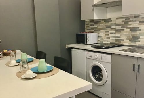 Modern kitchen and dining area at Casa Scola Loano B&B in Loano, Italy with white appliances