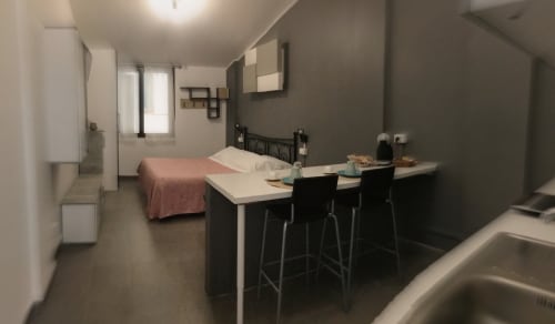 Modern studio room at Casa Scola Loano with bed, kitchenette, and dining counter in Loano, Italy