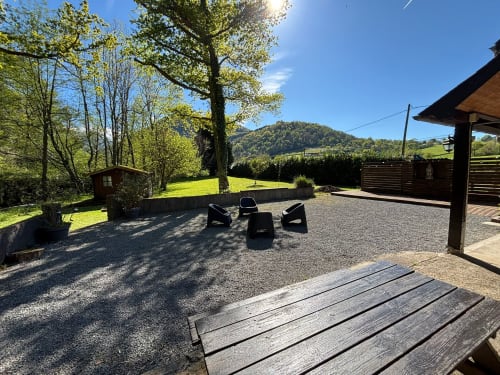 Scenic outdoor seating area at Le gite des mousquetaires in Lanne en Barétous, with mountain views and fire pit