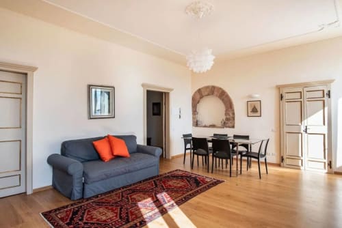 Spaziosa casa Clara ad Assisi con divano blu, zona pranzo, pavimenti in legno e volta in mattoni