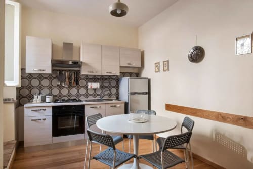 Cucina e zona pranzo moderna dell'appartamento Casa Clara ad Assisi, con mobili bianchi e tavolo rotondo