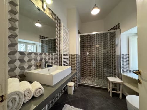 Bagno moderno nell'appartamento Casa Clara, Assisi con rivestimento geometrico, lavabo a bacinella, doccia walk-in e scaldaruvole