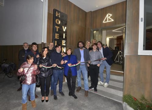 Gruppo che tiene il nastro all'ingresso dell'Hotel Vienna Pesaro durante la cerimonia di taglio del nastro