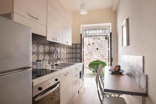 Cucina moderna nell'appartamento Casa Clara Dependance, Assisi - ante bianche, elettrodomestici in acciaio inox, piastrelle geometriche