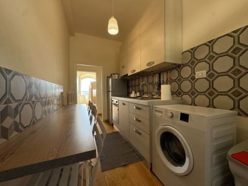 Cucina moderna con lavatrice nell'appartamento Casa Clara Dependance, centro di Assisi, con rivestimento geometrico e