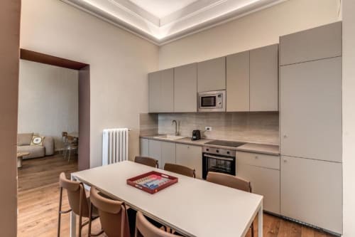 Cucina e zona pranzo moderna nell'appartamento The Great Chill a Roma con mobili beige e pavimenti in legno