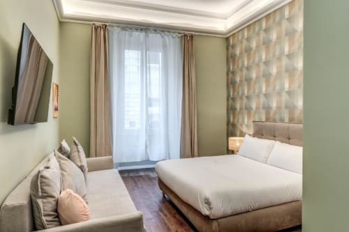 Camera da letto moderna all'appartamento Downtown Srl Roma con letto matrimoniale, TV, balcone con vista sulla città e arredi contemporanei