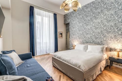 Elegante camera da letto a Roma con accenti blu, carta da parati decorativa, pavimenti in legno e comfort moderni a Downtown Srl