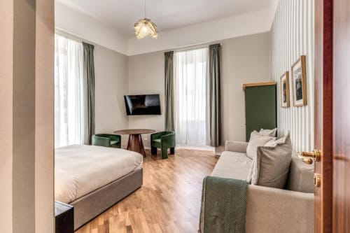 Ampia camera da letto con zona living, tavolo da pranzo e servizi moderni a Roma