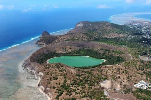 Vue aérienne du cratère volcanique au lac turquoise près de Mamoudzou, Mayotte, entouré de végétation luxuriante et côtier