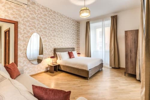 Camera da letto moderna dell'appartamento Downtown Nobu Roma con pavimenti in legno, carta da parati a motivi e accesso al balcone