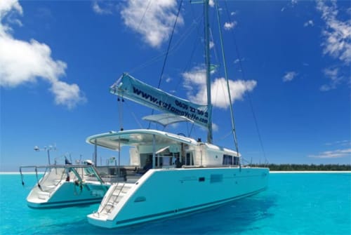 Catamaran turquoise avec voile mouillé dans des eaux cristallines près du Kaz Kafe, Mamoudzou