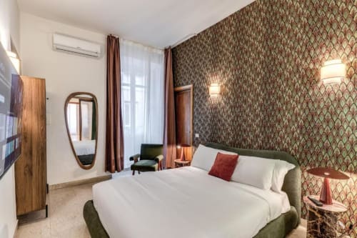 Camera moderna dell'apartment Downtown Nobu a Roma con letto imbottito verde, carta da parati decorativa e arredo contemporaneo