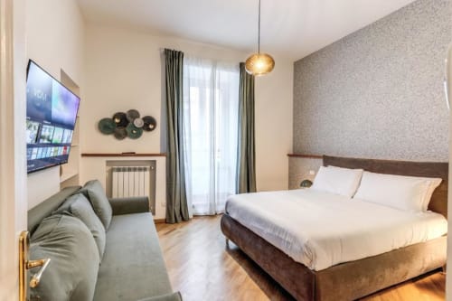 Camera da letto moderna nell'appartamento Downtown Nobu di Roma, con letto matrimoniale, TV, balcone, pavimenti in legno e arredamento contemporaneo