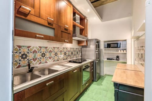 Cucina moderna nell'appartamento Downtown Nobu di Roma, con mobili in legno, piastrelle a motivi, elettrodomestici in acciaio inox e