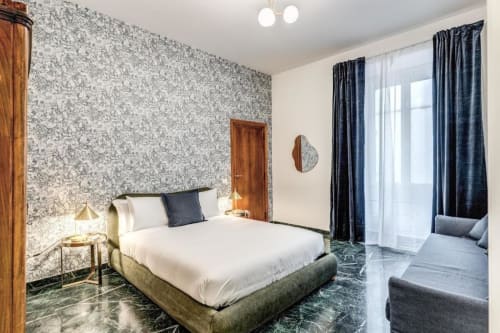Camera da letto moderna all'appartamento Downtown Nobu Roma con carta da parati texturizzata, letto queen, tende blu scuro e pavimento in marmo