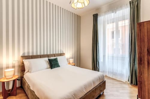Camera moderna nell'apartamento Nobu Rome Downtown con carta da parati rigata, letto in legno e balcone con vista sulla città