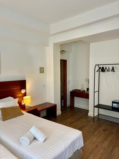 Moderno estúdio do hotel Hospedaria Buganvília em Alvor com cama, móveis em madeira escura, luminária amarela e kitchenette