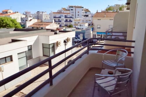 Terraço da Hospedaria Buganvília com cadeiras com vista para a paisagem urbana de Alvor e edifícios, vista da varanda do quarto estúdio