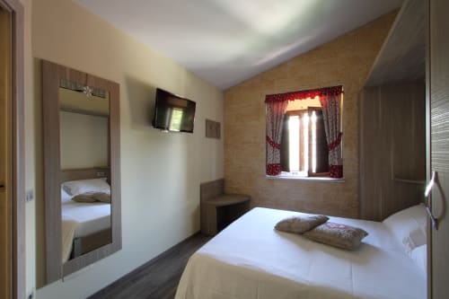 Ampia camera familiare connessa a Il Viottolo a Roccaraso con letto matrimoniale, TV e finestra con vista montagna