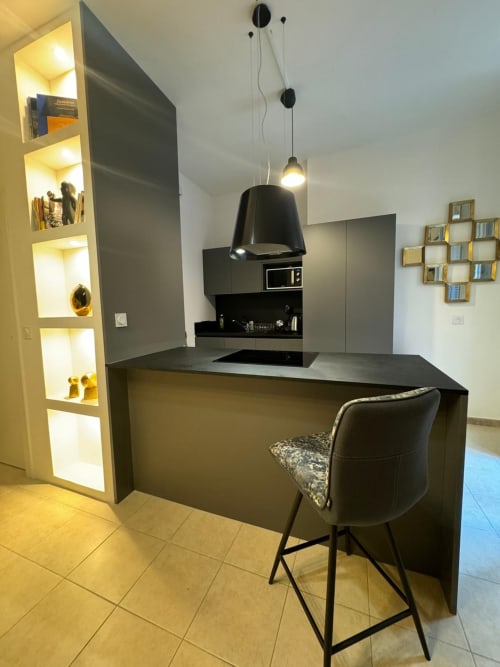 Cuisine moderne avec îlot noir et bar dans un spacieux appartement à Altezza, Bastia, France