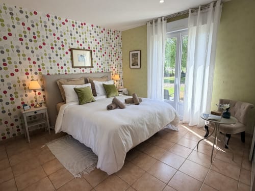 Chambre double lumineuse aux Vieilles Digues avec mur accent motifs, portes vue jardin et équipements modernes à Beauvoir