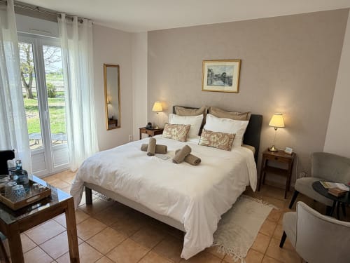 Spacieuse chambre double aux Vieilles Digues B&B à Beauvoir avec vue sur jardin, lit blanc, éclairage chaleureux