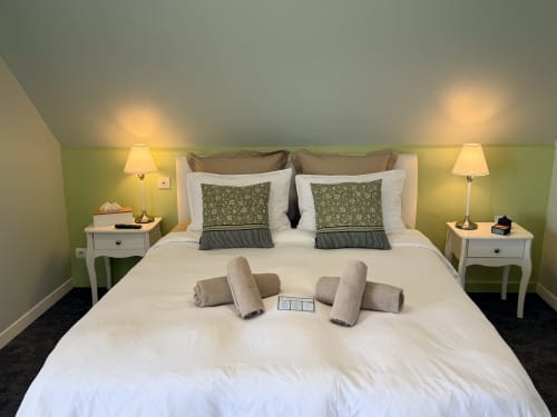 Chambre double lumineuse aux Vieilles Digues B&B, Beauvoir, murs verts, literie blanche et lampes avec vue sur jardin