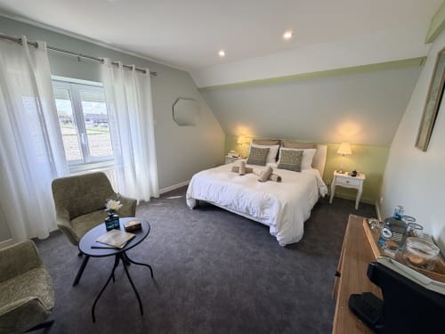 Spacieuse chambre double aux Vieilles Digues à Beauvoir avec vue sur le jardin, literie blanche, coin salon et équipements modernes