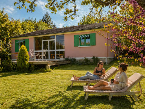 Two women relaxing in deck chairs on the lawn of La Villa Malzy in Vetheuil, France